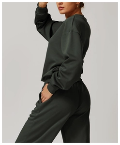Détail du sweatshirt vert forêt montrant les poignets côtelés et la texture du tissu premium