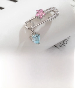 Detail of paperclip earring with pink star and light blue heart zirconia charms