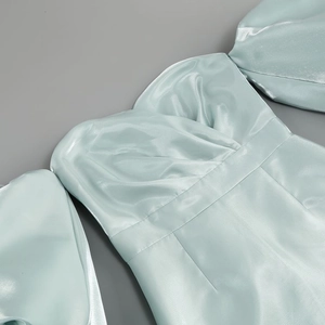 Close-up of light blue satin dress featuring elegant off-shoulder cut and puff sleeves