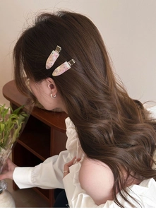 Detail of elegant water drop hair clips with rhinestones on wavy hair in a home setting