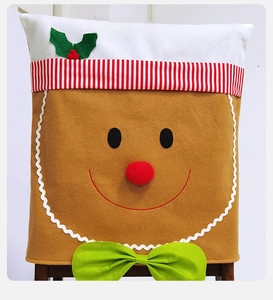 Detail of gingerbread man chair cover with festive red bow and holly leaf decoration