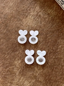 Detailed view of heart-shaped silicone earring backs with metal support on textured paper