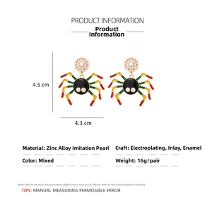 Macro detail of alloy spider earrings with faux pearl and colorful enamel inlays