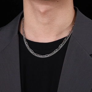 Detail of layered titanium steel chain necklace with OT buckle on a male model