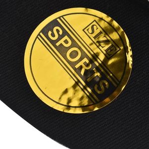 Macro shot of gold sports size sticker on black knitted fabric of a baseball cap