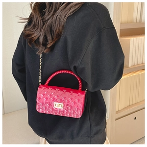 Detail of rose red jelly bag featuring quilted PVC texture and elegant beaded handle