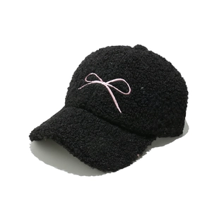 Women's black faux shearling baseball cap with pink bow embroidery on white background