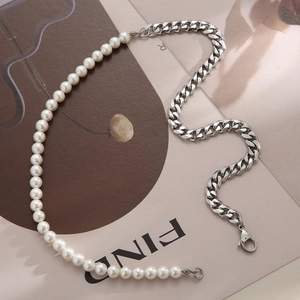 Detail of a half-pearl and stainless steel Cuban chain necklace on a lifestyle background