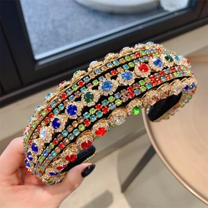 Close-up of a Baroque headband featuring colorful rhinestones on a gold metal frame