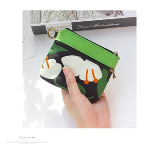 Détail du porte-monnaie en toile verte à fleurs avec double fermeture éclair et anneau
