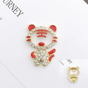 Macro view of cartoon tiger charm with rhinestones and red enamel 王 character detail