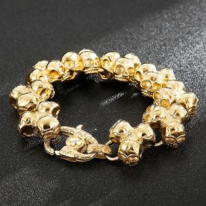 Macro detail of golden skull link bracelet with intricate cross engraved on the metal clasp