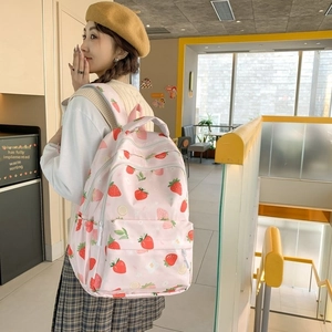 Side view of pink canvas backpack featuring cute strawberry and floral prints for students