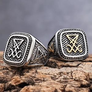 Macro shot of silver and gold Sigil of Lucifer stainless steel rings on rustic bark texture