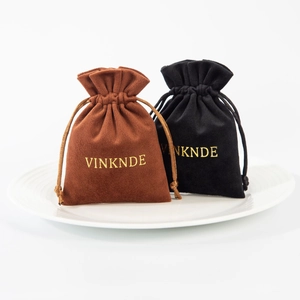 Brown and black velvet jewelry pouches with drawstring and gold embroidered logo detail