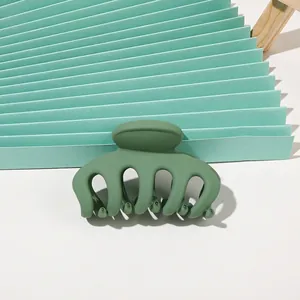 Close-up of matte dark green hair claw clip with a refined minimalist 5-tooth design