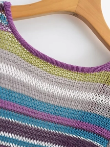Detail eines mehrfarbigen Netzkleid-Ausschnitts und Schulterstruktur auf einem Holzbügel
