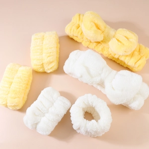 Detail view of soft coral fleece headband and wristband sets in white and yellow