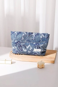 Detail of blue paisley jacquard cosmetic bag featuring woven H&R BAG brand label