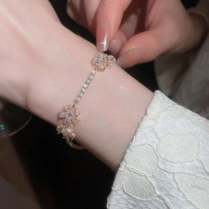Close-up of rose gold bracelet featuring intricate zircon flower charms on a delicate chain