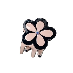 Pince à cheveux fleur en acétate avec pétales noirs et roses et strass central