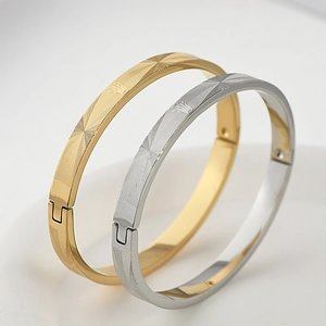 Detail of gold and silver steel bracelets with sunray texture and crown mesh pattern