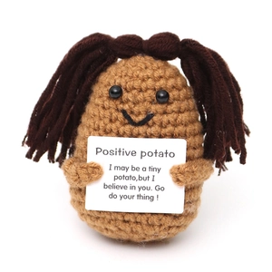 Close-up of crochet positive potato holding an encouraging message card on white background