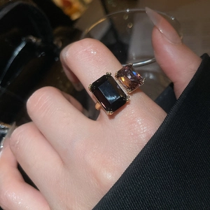 Macro detail of gold-plated geometric ring featuring dual rectangular zircon stones
