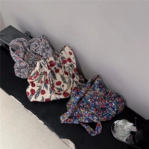 Three canvas tote bags with various floral patterns including red poppy and blue wildflower