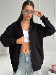 Detail of oversized black zip-up hoodie featuring ribbed cuffs and relaxed drop shoulder