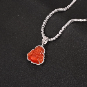 Macro shot of silver hip hop necklace with red opal Buddha pendant and white zircons