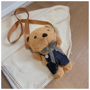 Detailed shot of brown teddy bear plush crossbody bag with denim overalls and strap