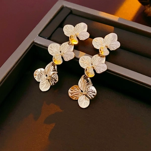 Macro shot of gold vintage flower earrings placed in a premium grey jewelry box