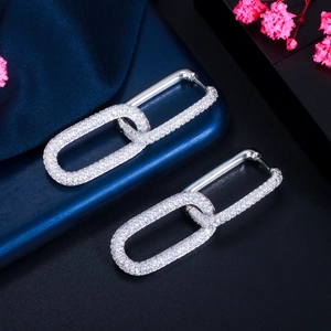 Detail shot of interlocking silver-tone chain earrings with micro-set white zircon stones
