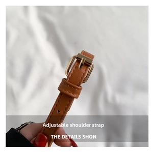 Close-up of caramel brown PU leather adjustable shoulder strap with gold metal buckle