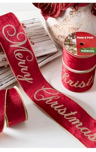 Detail of red velvet Christmas ribbon with gold Merry Christmas lettering on a roll