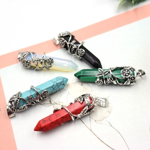 Détail de cinq pendentifs hexagonaux en pierre avec fil d'argent torsadé floral