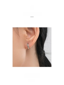 Close-up of minimalist S925 silver hoop earrings with square green zircon gemstones