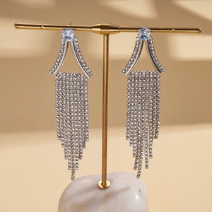 Vue détaillée de boucles d'oreilles géométriques argentées avec strass et pampilles