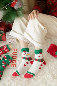 Close-up of cozy coral fleece Christmas socks with snowman pattern worn by a model