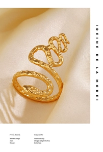 Detailed view of gold snake ring featuring hammer textured scales on satin background