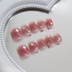 Pink blush gradient press-on nails with white stars and rhinestones in short square shape