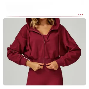 Detail of ribbed cuffs and hem on a dark red zip-up hoodie for women's sportswear