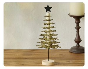 Detailed close-up of golden snowflake Christmas tree tabletop decor on wooden base