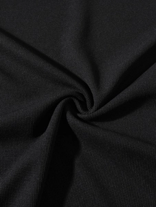 Close-up of black stretch knit fabric with micro-waffle texture and vertical ribbed pattern