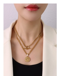 Detail of double-layer gold chain necklace with OT buckle and gun engraved coin pendant