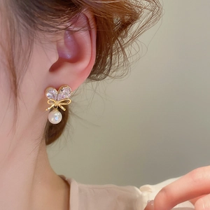 Elegant gold bow heart earrings with white pearls and sparkling cubic zirconia crystals