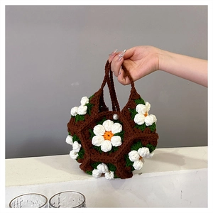 Detail of handmade brown crochet bag with white 3D flowers and pearl button closure