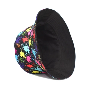 Detailed view of colorful ink splash graffiti pattern on a black street style bucket hat