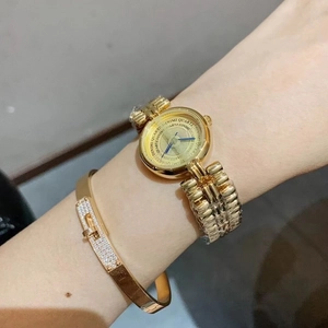 Close-up of golden women's quartz watch and sparkling diamond-encrusted bracelet set